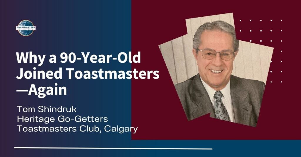 A Toastmasters promotional graphic featuring an older man in a suit and tie smiling, with text reading “Why a 90-Year-Old Joined Toastmasters—Again. Tom Shindruk, Heritage Go-Getters Toastmasters Club